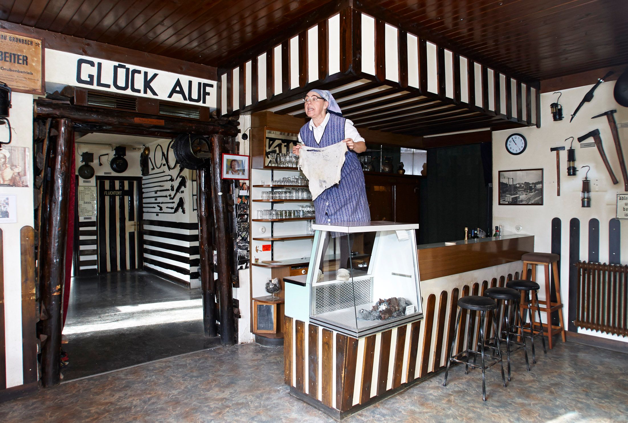 Interior view of a mining museum with a person in traditional clothing standing on a counter.