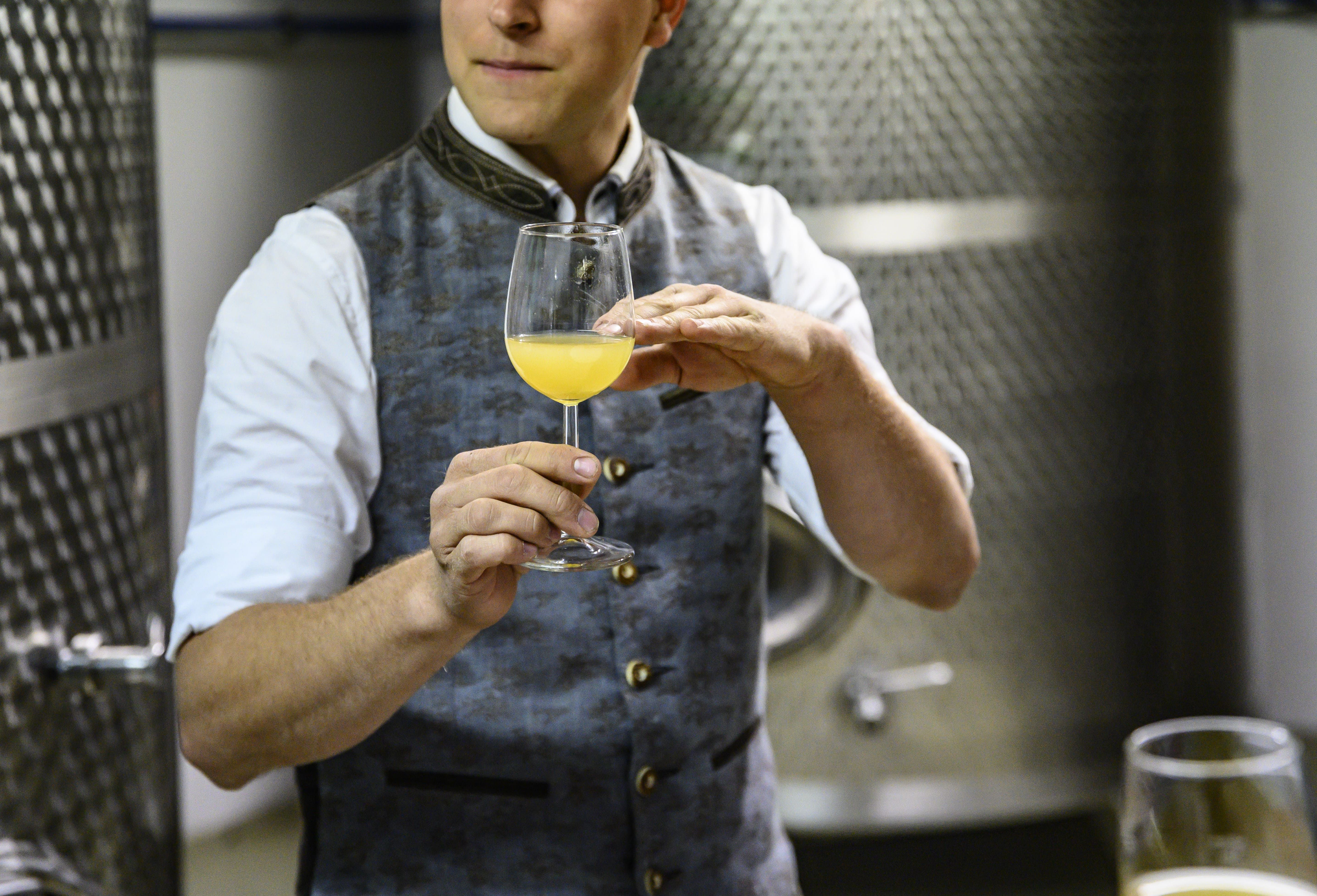 Person in traditional dress holding a glass of Cider
