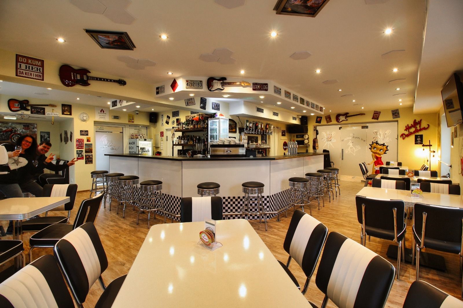 Innenansicht eines Rockabilly-Cafés mit Retro-Dekor und Barhockern.
