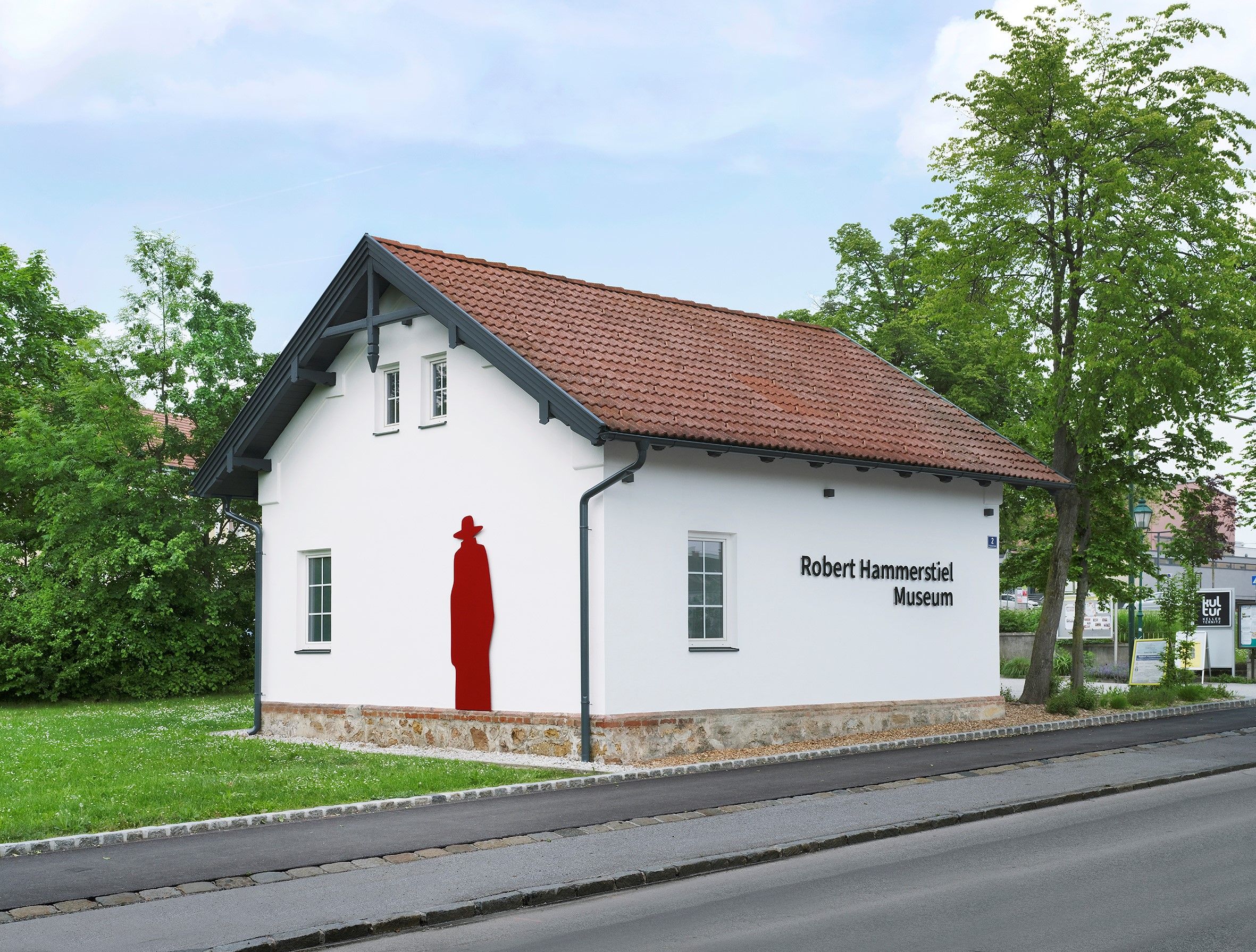 Exterior view of the Robert Hammerstiel Museum, with its white facade and a red artwork on the wall.